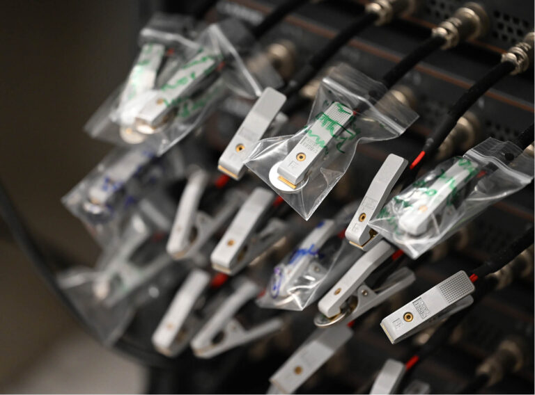 Lithium-ion pouch cells connected to a battery cycler for testing.