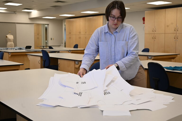 Highly Qualified Personnel Elena Kosareva laying out garment pattern pieces in her lab.