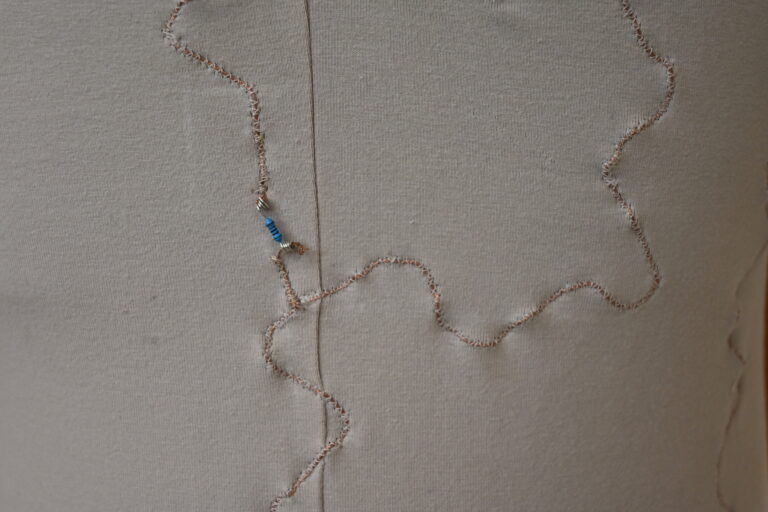 Close-up of a stitched copper thread circuit trace with an inline resistor. All photos: Aynaz Raoufian